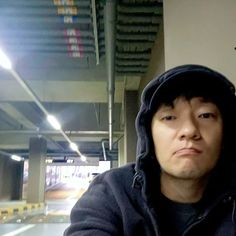 a man in a black hoodie holding a cell phone