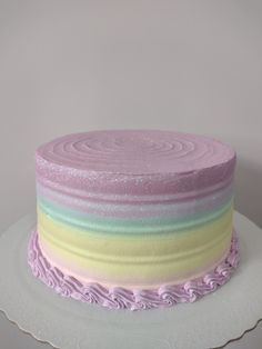 a cake with pastel frosting and decorative swirls on the top is sitting on a plate