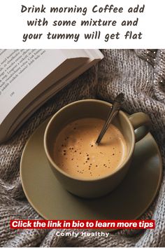 a cup of coffee sitting on top of a saucer next to an open book