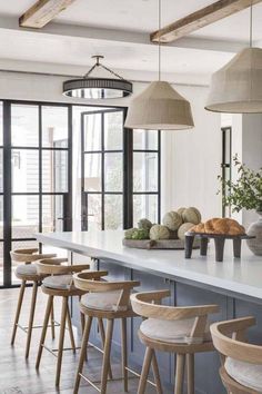 a kitchen filled with lots of counter space and wooden stools next to an island