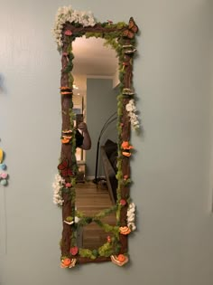 a mirror that is on the wall in front of a door with flowers and butterflies