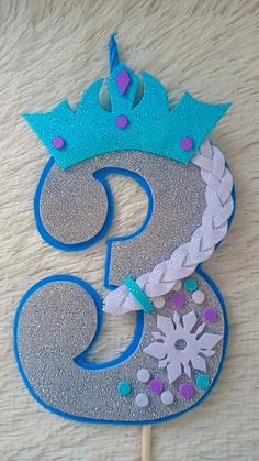 a cake topper that is shaped like a number 3 with a crown on it