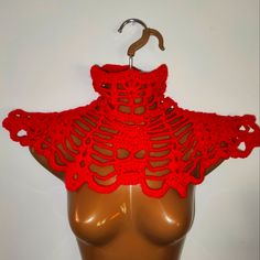 a mannequin wearing a red crocheted scarf on it's head