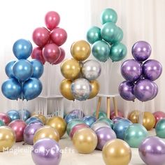 a bunch of balloons that are in the middle of a room with white walls and curtains