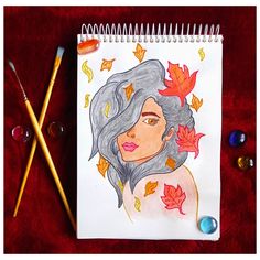 a drawing of a woman with leaves on her head and two pencils next to it