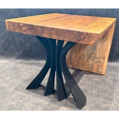 a wooden table with two metal legs and a piece of wood on the bottom side