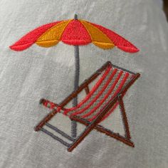 a beach chair with an umbrella embroidered on it