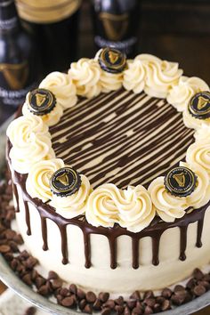 a cake with white frosting and chocolate swirls on top sitting on a table