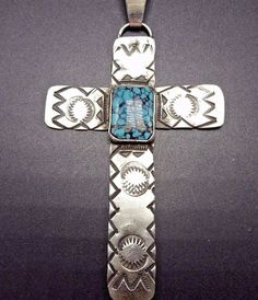 "VINTAGE NAVAJO CROSS PENDANT DESCRIPTION:This gorgeous pendant features a stunning cabochons of tightly webbed, deep blue turquoise. The gemstone is secure in smooth bezel, on a foundation of hand stamped vintage sterling silver. This pendant will be a lovely addition to your collection of fine vintage Native American jewelry. MEASUREMENTS: Pendant measures 3 3/4\" 9including bale) x 2 1/8\" Chain measures 20\" WEIGHT: Pendant weighs 18.2 grams Chain weighs 3.6 grams Total weight: 21.8 grams SI Artisan Engraved Blue Jewelry, Artisan Blue Engraved Jewelry, Handmade Turquoise Cross Jewelry, Blue Engraved Turquoise Pendant Necklace, Blue Turquoise Pendant Necklace With Engraving, Spiritual Hallmarked Turquoise Jewelry, Southwestern Style Blue Hallmarked Jewelry, Spiritual Turquoise Jewelry With Hallmark, Southwestern Blue Cross Jewelry