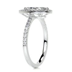 a white gold engagement ring with diamonds on the band and an oval shaped center stone