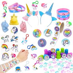 a bunch of toys that are on top of a white surface and in front of it is a person's hand