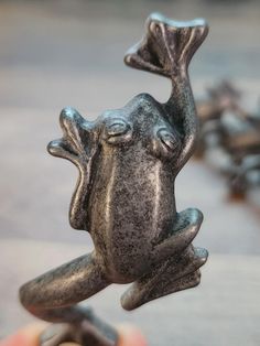 a small metal frog figurine sitting on top of a table