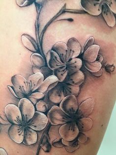 a close up of a tattoo with flowers on it