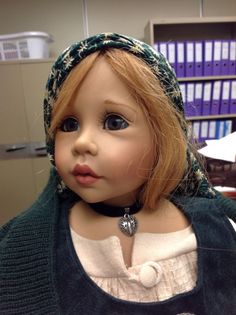 a close up of a doll wearing a head scarf