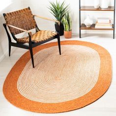 a chair sitting on top of a rug next to a potted plant