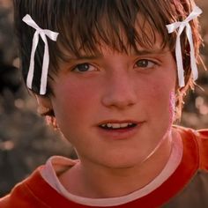 a close up of a child with two bows on their head