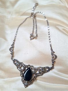 A circa 1920-30 choker lenght silver collier set with sparkly marcasites. The black drop-shaped center stone possibly an onyx. Hallmarked on the back with the swedish import marks for silver, and "835" for 835 silver on the clasp. Necklace lenght: approximately 38 centimeters. Box not included. Trackable shipping included. Feel free to message me with any questions! Silver Drop Necklaces For Evening, Silver Drop Necklace For Evening, Silver Art Deco Necklaces For Formal Occasions, Antique Black Sterling Silver Necklace, Silver Art Deco Necklace For Formal Occasions, Ornate Silver Teardrop Necklace, Evening Silver Necklace With Gemstone, Silver Gemstone Necklace For Evening, Vintage Silver Drop Jewelry