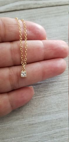 Dainty necklace features a tiny cz pendant that hangs from 14k gold filled and closes with a clasp. Looks great by itself or layered with your favorite necklace. Pendant measures 4mm x 6.6mm Select desired length from drop box. All your items will be packaged and shipped in a cotton filled kraft box. ~The best way to prevent tarnish is to wear your jewelry regularly. When not wearing your jewelry, the best way to protect it is to store it in a sealed plastic bag. Humidity, chemicals and chlorine Dainty Yellow Gold Square Pendant Charm Necklace, Everyday Delicate Cubic Zirconia Charm Necklaces, Elegant Tiny Charm Necklaces In 14k Gold Filled, Dainty Jewelry With Delicate Chain And Square Pendant, Dainty Solitaire Pendant Necklace For Everyday, Dainty 14k Gold Charm Necklace With Square Pendant, Gold Solitaire Necklace With Delicate Chain For Everyday, Everyday Gold Solitaire Necklace With Single Diamond, Dainty Tiny Charm Necklaces Gold Plated