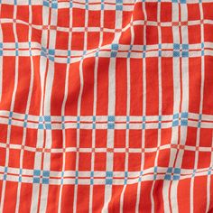 an orange and white checkered fabric with blue dots on the top, as if it were woven into something else