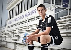 a young man sitting on the bleachers holding a soccer ball in his hands