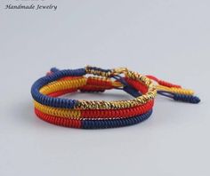 three different colored bracelets with gold and blue beads