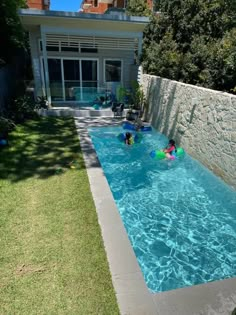 two children in the pool playing with their boogie boards and swimming toys on a sunny day