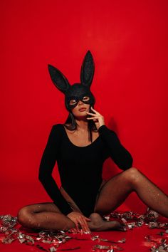 a woman sitting on the floor wearing a bunny mask