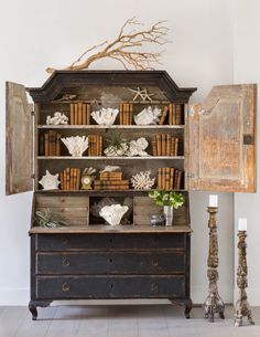 an old bookcase with books and other items on it, next to a lamp