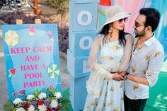 a man and woman standing next to a sign