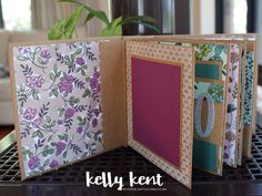 the inside of an open card with flowers and leaves on it, sitting on a table next to a potted plant