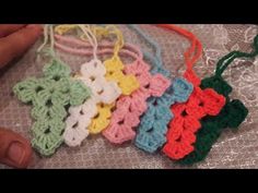 small crocheted ornaments are being held by someone's hand on a table