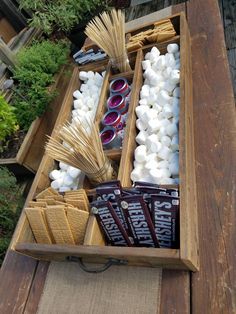 a wooden box filled with marshmallows and other items