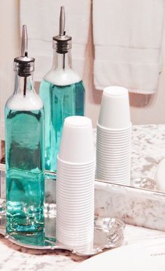 two bottles are sitting next to each other in front of a mirror on the counter