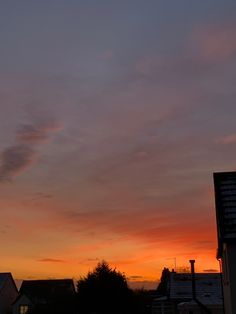 the sun is setting over some houses and buildings