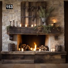 a fireplace with lit candles and logs in front of it