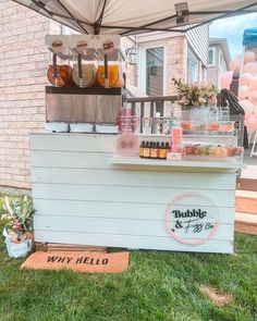 an outdoor stand with drinks on it in the grass