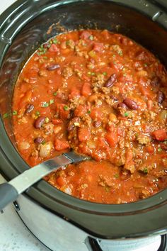 a slow cooker filled with chili and meat