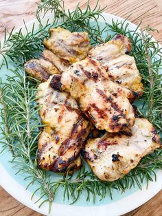 grilled chicken on a plate with rosemary sprigs