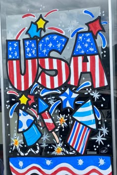 a glass sign with the word usa painted on it and stars, stripes, and fireworks