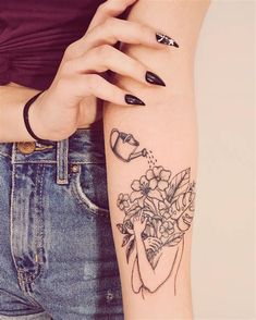 a woman's arm with a flower tattoo on the left side of her arm