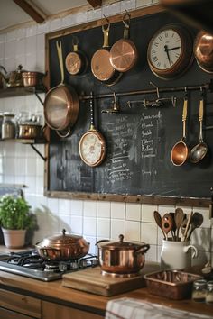 a kitchen with pots and pans hanging on the wall next to a chalkboard