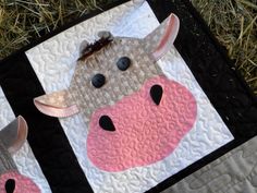 the cow is made out of quilts on the ground with grass in the background