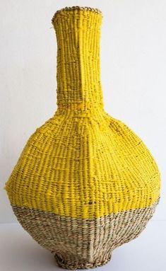 a yellow vase sitting on top of a white table