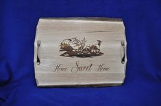 a wooden plaque with the words home sweet home and two horses on it, sitting on a blue background