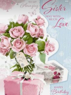 a card with pink roses in a vase on top of a table next to a cake