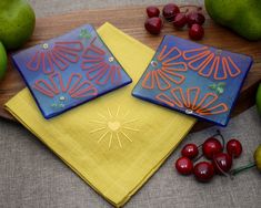 two blue and yellow plates sitting on top of a table next to some cherries