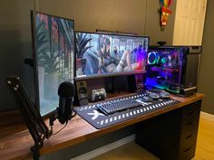 two computer monitors sitting on top of a wooden desk next to a keyboard and mouse