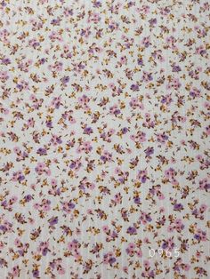 a white fabric with purple and yellow flowers on it's side, as well as the bottom half