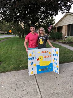 a man and woman standing next to a sign that says lucky you'd be ducky go with me