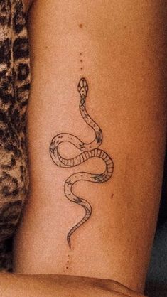 a woman's arm with a snake tattoo on the left side of her body